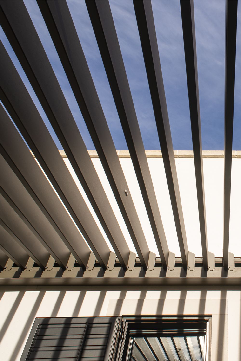 Estrutura metálica com lâminas paralelas sobre uma área externa